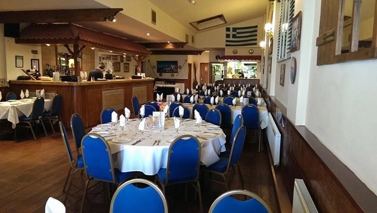 The dining room set for service with a round table and blue chairs