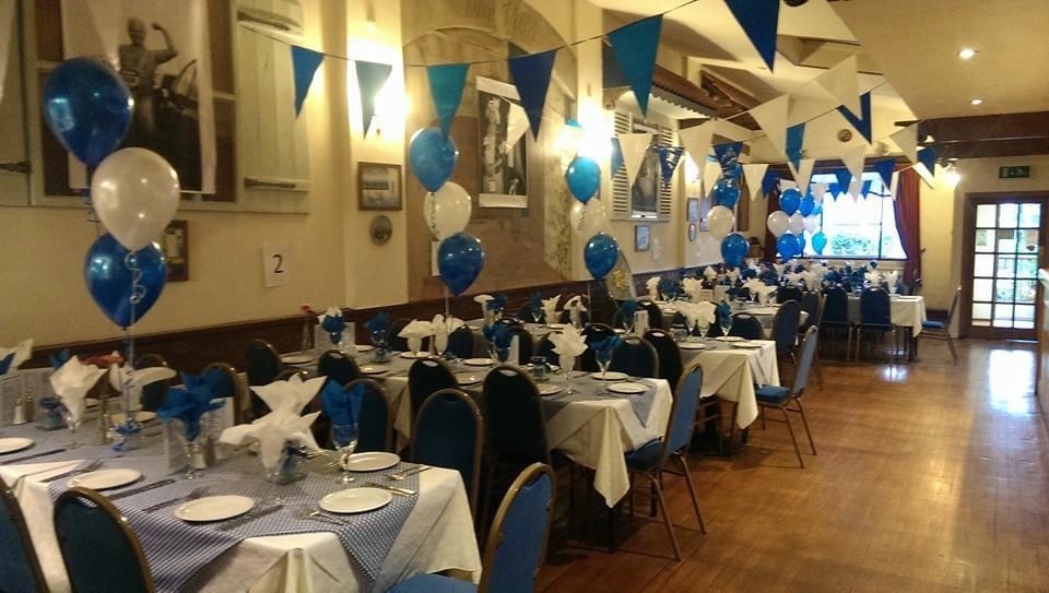 The dining room dressed with blue and white balloons and bunting for a party