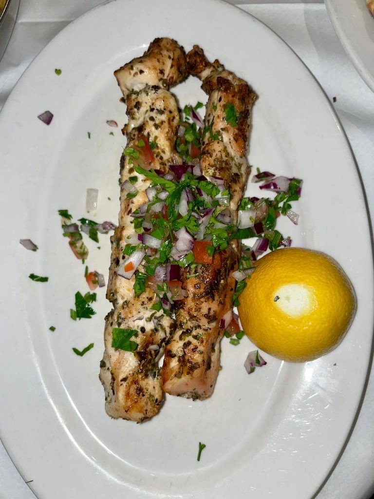 Grilled chicken souvlaki skewers with onion, tomato and lemon