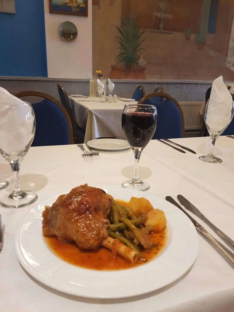 Slow-cooked lamb shank with green beans and potatoes, red wine