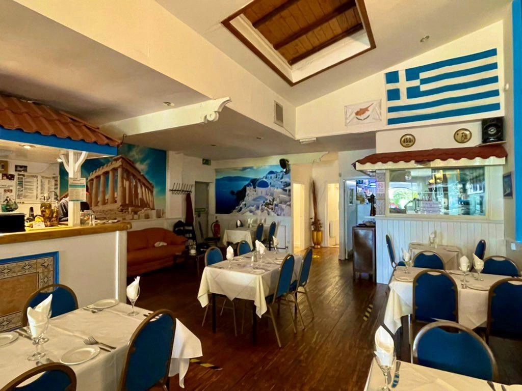 Tables laid beneath the Greek flag in the main dining room