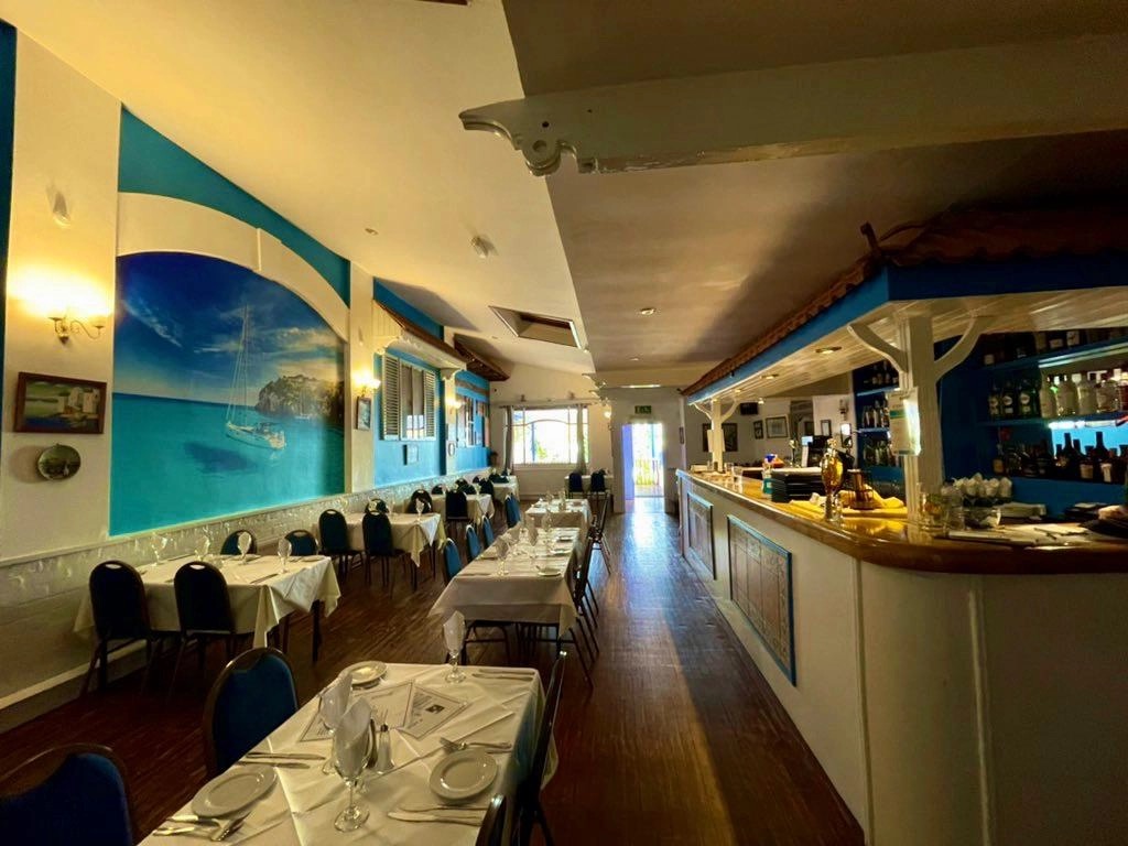 The dining room with hand-painted seascape mural and long bar