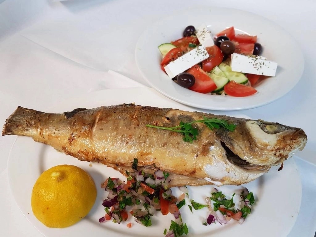 Whole grilled fish with lemon, salsa and Greek salad
